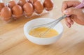 Male hand mixing eggs in bowl
