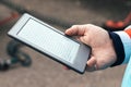 Male hand with modern gray electronic book. Reading books everywhere with a pocket reader or tablet Royalty Free Stock Photo