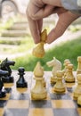 The male hand moves the white bishop chess piece on the board