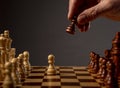 Male hand moving pawn on chess board, starting game. Making business decision concept Royalty Free Stock Photo