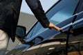 Male hand opening car door handle. Unrecognizable man buying vehicle in dealership. Man in black suit opens black Royalty Free Stock Photo