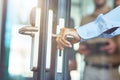 Male hand opening glass door in the modern office, close up shot Royalty Free Stock Photo