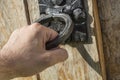 Male hand opening old wooden door with very old door handle Royalty Free Stock Photo