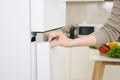 Male hand is opening white refrigerator door Royalty Free Stock Photo