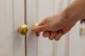 Male hand opens door of white wall cupboard. Royalty Free Stock Photo