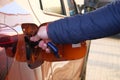 Male hand opens fuel fill in car. Fueling car with petrol pump at gas station. Petrol station. Gasoline and oil products. Close up Royalty Free Stock Photo