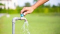 Male hand opens the garden water tap, pouring clean fresh water water tap, turn on tap,Hands-off water. Royalty Free Stock Photo