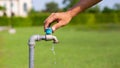 Male hand opens the garden water tap, pouring clean fresh water water tap, turn on tap,Hands-off water. Royalty Free Stock Photo