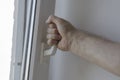 Male hand opens the window by the handle