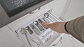 Male hand picks some table kives from kitchen drawer