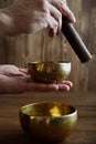 Male hand playing on Tibetan handcrafted singing bowls