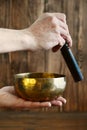 Male hand playing on Tibetan handcrafted singing bowls