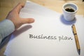 Male hand pointing at a business plan printed on a white sheet of paper during a business meeting