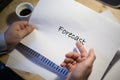 Male hand pointing at a forecast document printed on a white sheet of paper during a business meeting