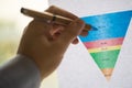 Male hand pointing at a coloured funnel chart printed on a white sheet of paper during a business meeting