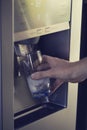 Cold water and ice cubes from dispenser of home fridge