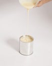 Male hand pouring condensed milk into a tin can Royalty Free Stock Photo