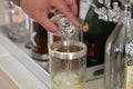 Male hand pouring shot of tequila into glass with ice