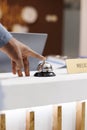 Male hand pressing hotel front desk bell Royalty Free Stock Photo