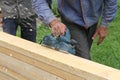 The male hand processes a wooden board an electric planer Royalty Free Stock Photo