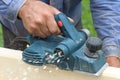 The male hand processes a wooden board an electric planer Royalty Free Stock Photo