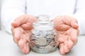 Male hand protected money glass jar bank Royalty Free Stock Photo