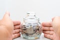 Male hand protected money glass jar bank Royalty Free Stock Photo