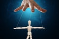 Male hand, puppeteer controls the puppet puppet with strings. The concept of shadow government, world conspiracy, manipulation,
