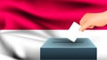 Male hand puts down a white sheet of paper with a mark as a symbol of a ballot paper against the background of the Indonesia flag