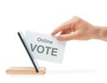 Male hand putting a ballot into a mobile phone, concept of online voting.