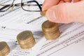 Male hand putting money on growing coin stack