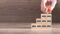 Male hand putting wood cube leader on pyramid Royalty Free Stock Photo