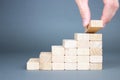 Male hand putting wooden blocks in the form of a ladder. The concept of building a success Royalty Free Stock Photo