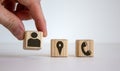 Male hand putting wooden cube with human icon near other cubes with geoposition and phone marks, contact and information icons Royalty Free Stock Photo