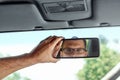 Male hand on the rearview mirror of a car, close-up. Manual adjustment of a rear-view mirror Royalty Free Stock Photo