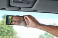 Male hand on the rearview mirror of a car, close-up. Manual adjustment of a rear-view mirror Royalty Free Stock Photo