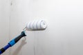 male hand with a roller for painting walls. The painter applies decorative paint to the wall.repair inside the house Royalty Free Stock Photo