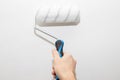 male hand with a roller for painting walls. The painter applies decorative paint to the wall.repair inside the house Royalty Free Stock Photo