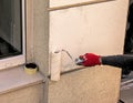 Male hand with a roller paints the wall with beige paint. Royalty Free Stock Photo