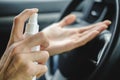 Male hand with sanitizer spray disinfect the surface of his hand in a car. Covid-19 Coronavirus Quarantine Pandemic