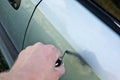 male hand scratches car wing with key Royalty Free Stock Photo