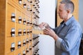 A male hand searching cards in old card catalogue. Man searching file Royalty Free Stock Photo