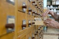 A male hand searching cards in old wooden card catalogue. Royalty Free Stock Photo