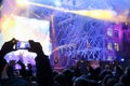 Male hand shoots video by smartphone during concert with laser s