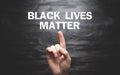 Male hand showing Black Lives Matter text on black background