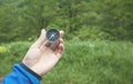 Male hand showing compass in forest