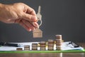 Male hand showing house keys over stack of coins Royalty Free Stock Photo