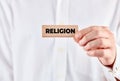 Male hand shows a wooden block with the word religion Royalty Free Stock Photo