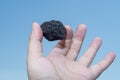 Male hand with a small piece of coal Royalty Free Stock Photo