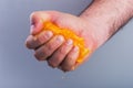 Male hand squeezing orange. Royalty Free Stock Photo